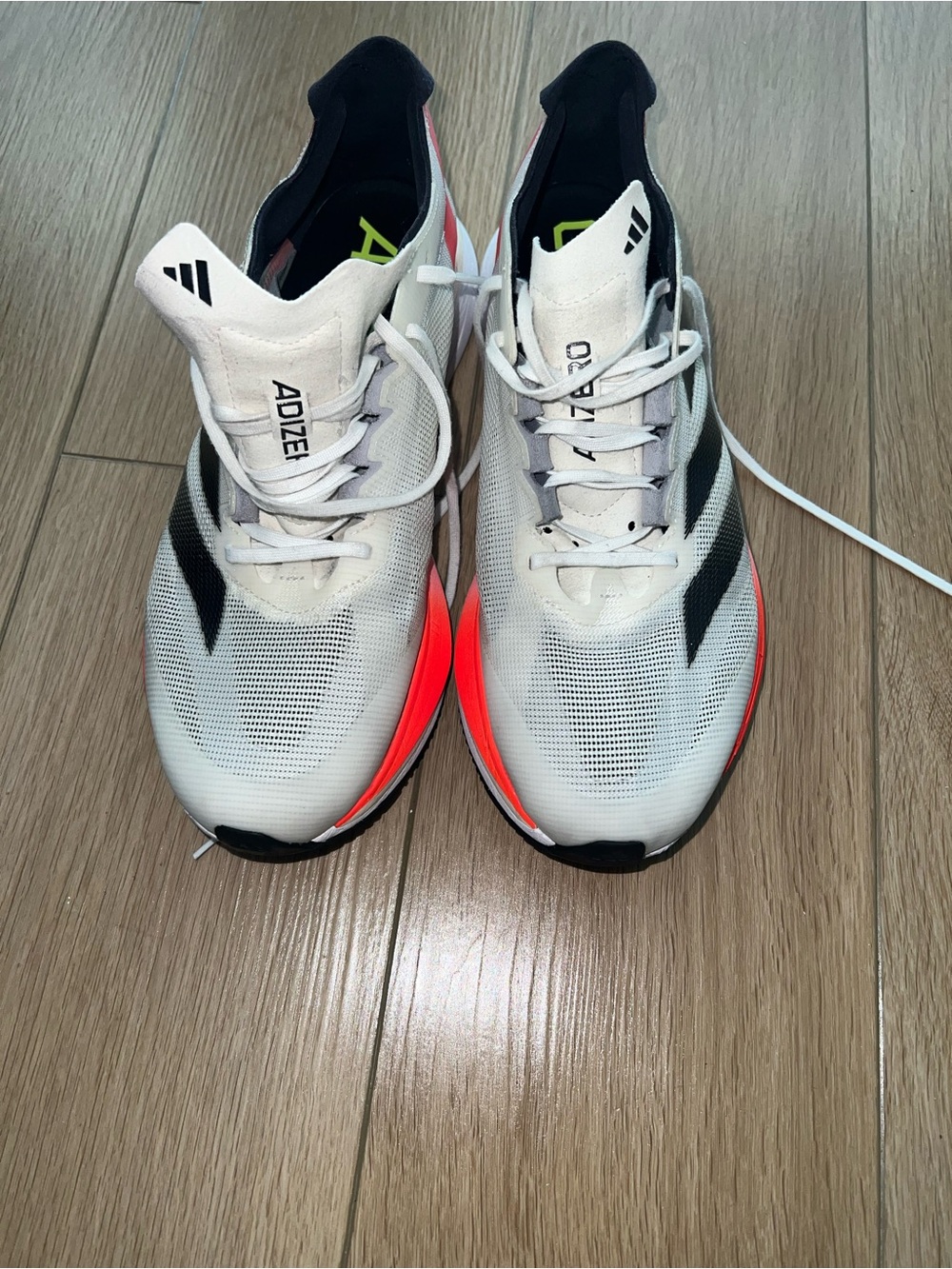 adidas White Running Shoes with Black Stripes and Neon Orange Accents